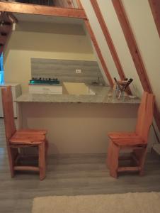 - une cuisine avec un comptoir et 2 chaises dans l'établissement Topi Cottages, à Nanyuki