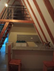 une cuisine sous une mezzanine avec un escalier dans l'établissement Topi Cottages, à Nanyuki