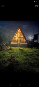 une grande maison avec une grande fenêtre sur un champ dans l'établissement Topi Cottages, à Nanyuki