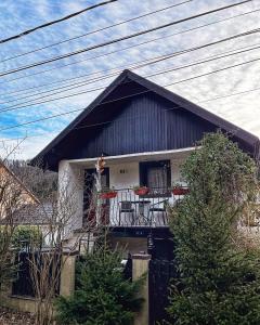 a house with a balcony with chairs on it at CasaMaria in Slănic-Moldova