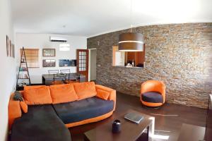 a living room with a couch and a brick wall at Spacious Family Oasis in Tavira by Lisbeyond in Tavira