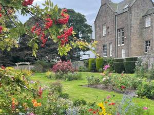 un giardino di fronte a un edificio fiorito di Mall House self catering apartment a Montrose