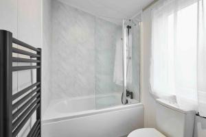 a white bathroom with a tub and a toilet at Host & Stay - Linden Lodge, Ashdown Retreat in Pickering