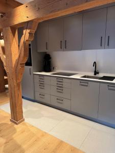 a kitchen with white cabinets and a wooden beam at Ferienwohnung Zum Wunsch in Rottach-Egern