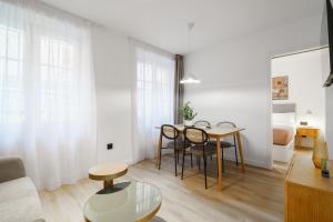 a living room with a table and chairs and a bed at Limehome Malaga Calle Victoria in Málaga
