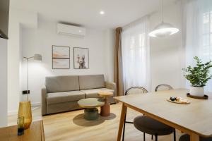 a living room with a couch and a table at Limehome Malaga Calle Victoria in Málaga +43 photos