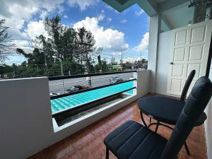 a balcony with a view of a swimming pool at จิมเบ โคซี่เทล เขาหลัก Zimbei Cozytel Khaolak in Khao Lak