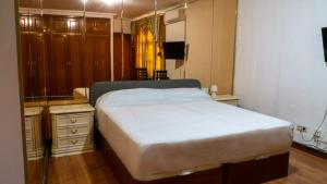 a bedroom with a large white bed and a dresser at SunDos Feria Valencia in Valencia