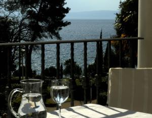 stolik z dwoma kieliszkami na balkonie z widokiem na ocean w obiekcie Hotel Villa Vera w mieście Lovran