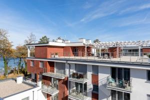 a red brick building with a balcony on top of it at Apartamenty Klifowa in Rewal