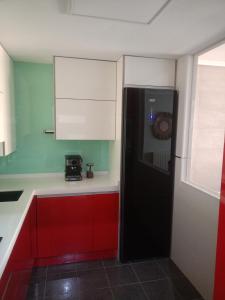 a kitchen with a black refrigerator and red cabinets at Los ojos del castillo in Soria