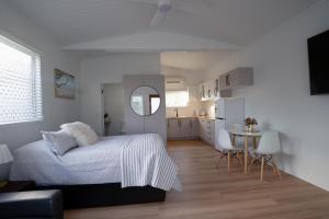 Mountain CreekにあるStudio Flat with kitchenのベッドとキッチンのある白い寝室