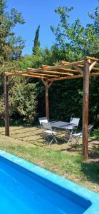 pergolato in legno con due sedie e un tavolo accanto alla piscina di Quinta Las Ardillas lujan a Luján Altre 42 foto