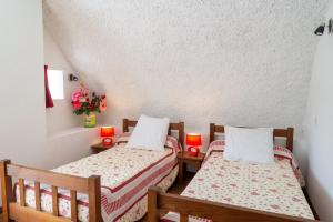 two beds in a small room with red candles at Aux cimes des gorges du tarn in Laval-du-Tarn