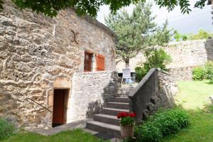 a stone house with stairs leading to a door at Aux cimes des gorges du tarn in Laval-du-Tarn