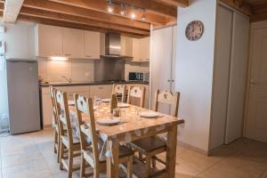 a kitchen with a wooden dining table and chairs at Gîte à albaret in Albaret-Sainte-Marie