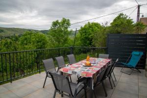 Una mesa y sillas en un balcón con vista. en La grange d'elie et rosa, en Le Pont-de-Montvert