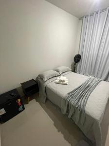 a bedroom with a bed with two towels on it at Caverna Suítes - Suítes na praça matriz in São Thomé das Letras