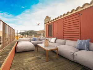 d'une terrasse avec des canapés et une table sur un balcon. dans l'établissement Casa Indiana en el corazón de Begur, à Begur
