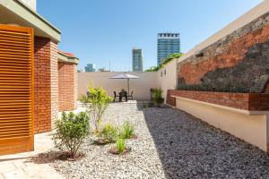 a courtyard with a brick wall and a table with an umbrella at Amplia, cálida y súper ubicada in Mendoza