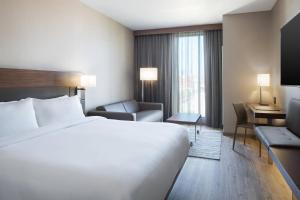 a hotel room with a large bed and a desk at AC Hotel by Marriott Louisville Downtown in Louisville