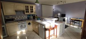 a kitchen with white cabinets and a counter top at Maison Cosy avec jardin - Paris - 4 Pers - in Aulnay-sous-Bois