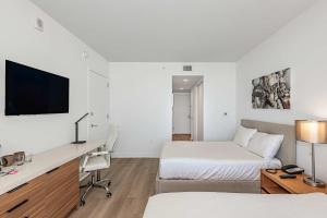 a hotel room with two beds and a desk at Lovely Studio with Amazing Views in Hallandale Beach