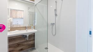 a bathroom with a sink and a shower at VacationClub - Aparthotel Czarna Góra Apartament 323 in Sienna