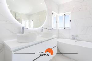 a white bathroom with two sinks and a mirror at #221 Cerro Grande by Home Holidays in Páteo +62 photos