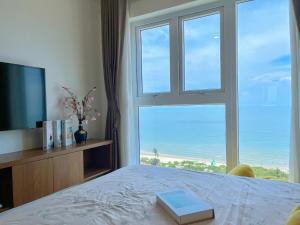 Un dormitorio con un gran ventanal con vista al mar. en Mermaid seaview Vũng Tàu - Khang Apartment 1, en Vung Tau