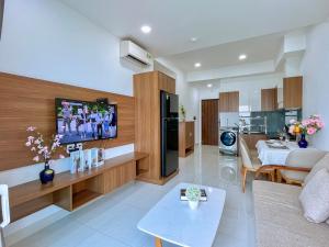 Una sala de estar con un sofá y un televisor. en Mermaid seaview Vũng Tàu - Khang Apartment 1, en Vung Tau