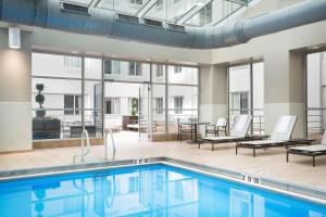 an indoor pool with lounge chairs and a table and a tablektop at AC Hotel Chicago Downtown in Chicago