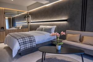 a bedroom with a bed and a table and a couch at Polyzos Luxury Suites Meteora #1 - Adults Friendly in Kalabaka