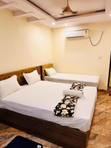 a bedroom with two beds and a air conditioner on the wall at Hotel Royal Palace in Gaya +5 photos