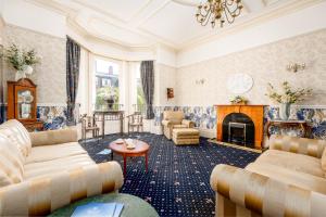 a living room with couches and a fireplace at Bournemouth Sands Hotel in Bournemouth
