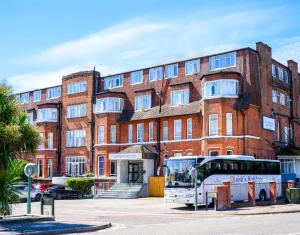 a bus parked in front of a brick building at Bournemouth Sands Hotel in Bournemouth