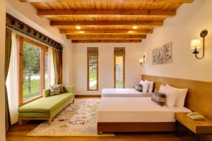 廷布Lemon Tree Resort, Thimphu, Bhutan的一间卧室配有两张床和一张绿色沙发