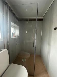 a shower with a glass door in a bathroom at Turifoss Camping Cabin 1 in Meråker +20 photos