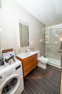 Un baño con lavadora y un inodoro. en Peaceful Corner Penthouse 3 bed with views, en St Paul's Bay