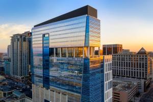 a tall building with glass windows in a city at AC Hotel by Marriott Orlando Downtown in Orlando