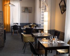 ein Restaurant mit Tischen und Stühlen in einem Raum in der Unterkunft La Villa Rose-Marie in Saint-Brevin-les-Pins