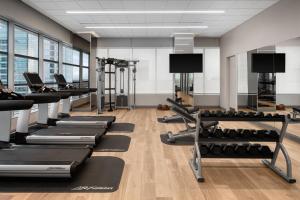 a gym with rows of treadms and pilates equipment at AC Hotel by Marriott Orlando Downtown in Orlando