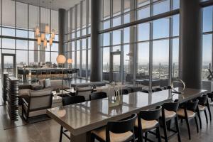 a dining room with tables and chairs and large windows at AC Hotel by Marriott Orlando Downtown in Orlando