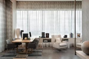 a living room with a table and chairs and a large window at AC Hotel by Marriott Orlando Downtown in Orlando
