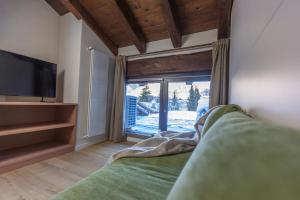 a living room with a couch and a large window at L'Atelier du Temps - Petit Jano in La Thuile