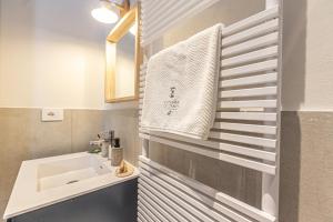 a bathroom with a sink and a white towel at L'Atelier du Temps - Petit Jano in La Thuile +44 photos
