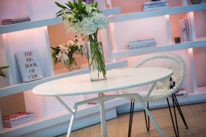 a vase of flowers sitting on a table with two chairs at Renaissance Santo Domingo Jaragua Hotel & Casino in Santo Domingo +37 photos