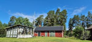 a red barn and a red building in a field at Hemma fran Hemma - The Fantasy House in Kvillsfors