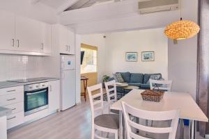 Una cocina y una sala de estar con mesa y sillas. en Villa Ourania Periyali, en Vasilikos