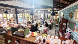 a restaurant with two women sitting at a counter at Pousada Uluwatu, Praia do Rosa in Praia do Rosa